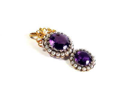 un gros plan sur une paire de boucles d'oreilles ornées de pierres violettes