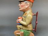 two figurines of a man sitting on a bench