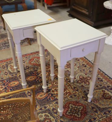 une paire de tables d'appoint blanches posées sur un tapis dans un salon