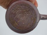 a hand holding a brown cup with writing on it