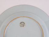 a white plate with a gold rim sitting on a table