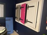 Des volets aux couleurs vives sont accrochés au mur d'une salle de bains