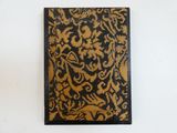 un vieux livre orné d'un motif doré et noir