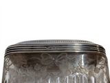 a glass box with a silver lid on a table