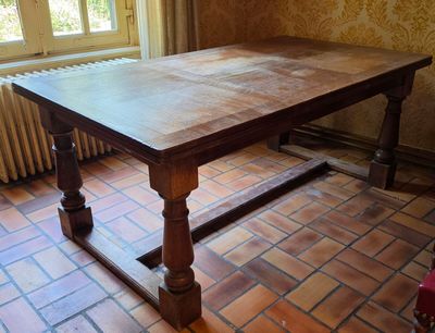 une grande table en bois dans une pièce au sol en briques