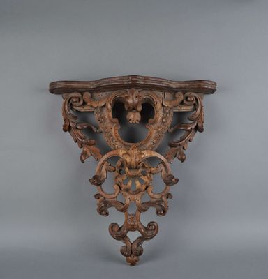 an ornately carved wooden shelf with a lion head on it