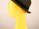 une tête de mannequin jaune coiffée d'un chapeau marron