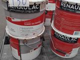 trois seaux de peinture posés sur une palette dans un entrepôt