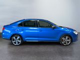 the blue car is parked in a large room with a white wall