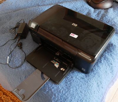 une imprimante noire posée sur une couverture bleue