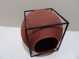 a red ball inside of a black box on a white table