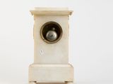 a white clock that is sitting on a table