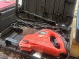 a red cordless tool in a black case on a table