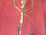 a statue of a woman holding a chandelier on a red wall
