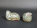 pair of ceramic bird figurines on a black background
