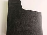 a close up of a piece of black paper on a white surface