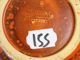 a close up of a brown and yellow vase with a sticker on it