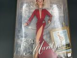 the doll is in a box with a picture of a woman in a red dress