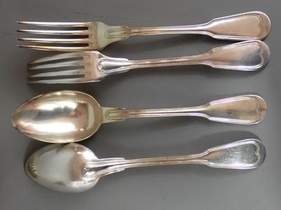 quatre cuillères en argent et deux cuillères en argent sur une table