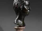 a bronze bust of a woman on a pedestal