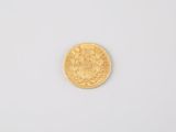 a close up of a gold coin on a white surface