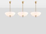 the three light chandelier in brass with white glass shades