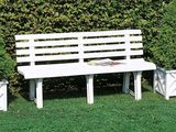 un banc blanc posé au milieu de la pelouse