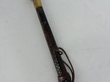 a wooden stick with a handle on a white surface