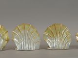 three glass vases with leaves on them sitting on a table