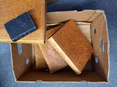 une boîte remplie de livres et un téléphone portable par terre