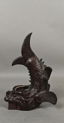 deux petites figurines de poissons en bois posées sur une table