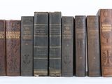 plusieurs vieux livres sont alignés sur une surface blanche