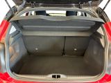 a red car with its trunk open in a garage