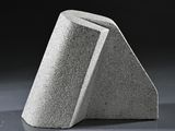 concrete sculpture of a triangular shaped object on a gray surface