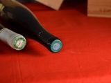 two bottles of wine sitting on a red table