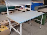 une table surmontée d'une étagère, dans un entrepôt