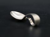 a spoon and a spoon rest on a black surface