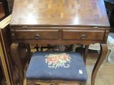 un petit bureau en bois avec un tabouret devant