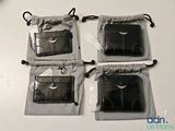 trois portefeuilles en cuir noir posés sur une table blanche