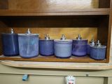many blue pots and pans on a shelf in a cabinet