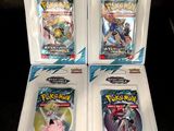 three packs of pokemon trading cards in plastic cases on a table