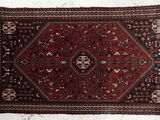 un tapis rouge et noir accroché à un mur blanc