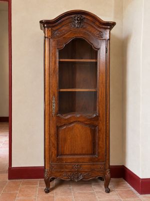 un meuble en bois avec une porte en verre dans une pièce