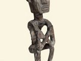 an image of a wooden sculpture of a man holding a baby