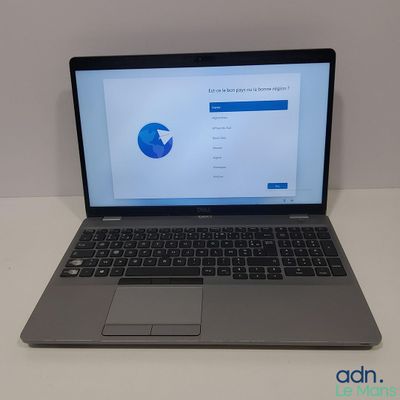un ordinateur portable ouvert posé sur une table blanche