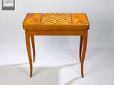 une petite table en bois sur laquelle se trouve un échiquier