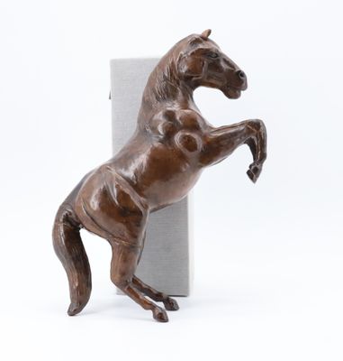 statue d'un cheval debout sur ses pattes arrière, à côté d'une boîte
