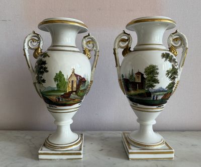 deux vases posés sur une table, sur lesquels est représenté un tableau