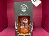 une bouteille de whisky dans une boîte rose, posée sur une étagère
