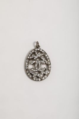a silver pendant with a circular design and small diamonds on it